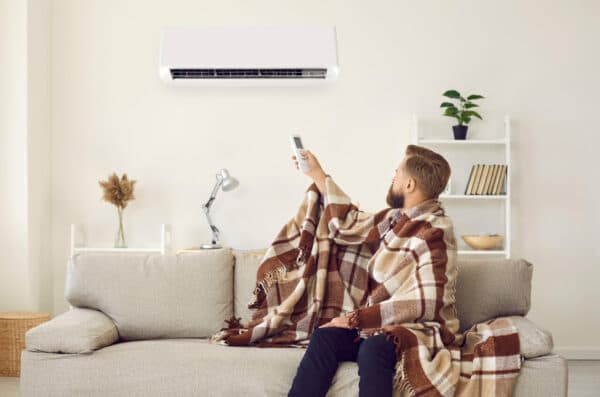 Man having problem with his air conditioning system and freezing in his cold apartment